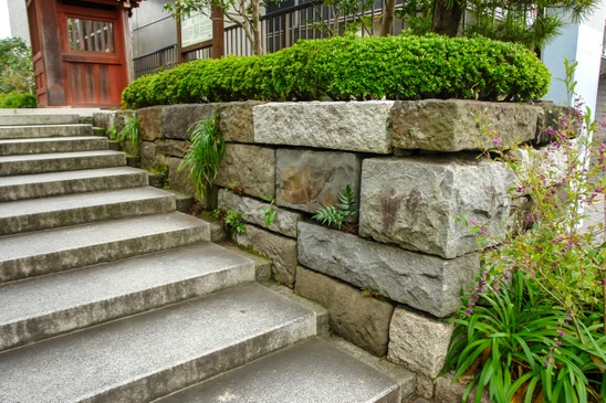 Aménagement paysager extérieur avec escalier en béton et mur de soutènement en blocs de pierre naturelle
