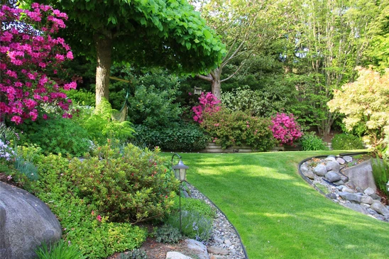 Jardinier professionnel aménageant un jardin paysager extérieur, construisant un muret en pierres naturelles